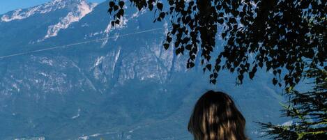 A woman sitting on a bench with a mountain view in the background.