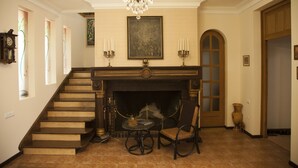 A grand staircase leading to a fireplace with a chandelier above. - Hin Yerevantsi (Yerevan)