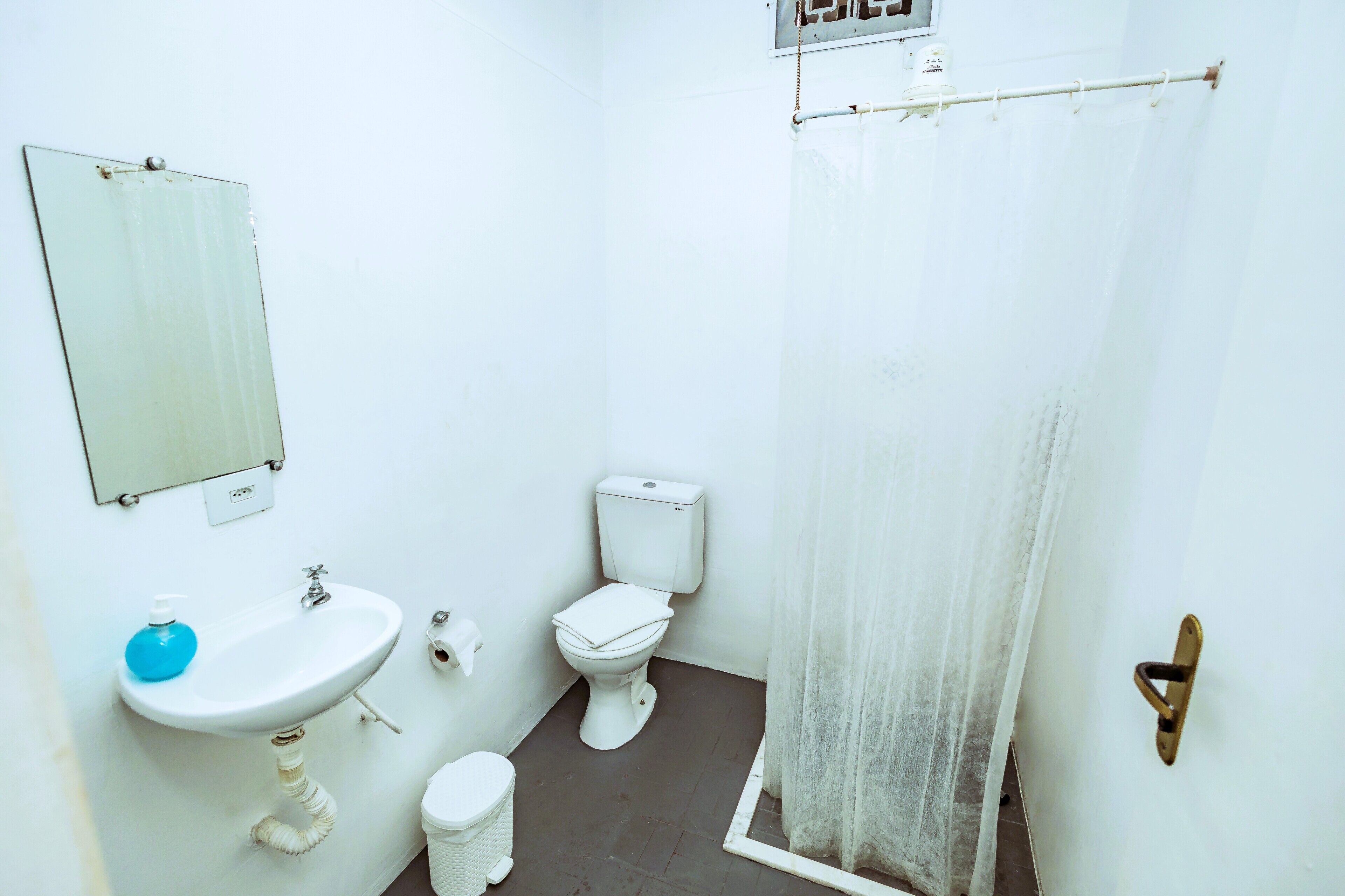 A small, clean bathroom with a sink, toilet, and a mirror.