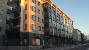 A multi-story building with a modern architectural design, featuring balconies and large windows. - RovaVisit Center (Rovaniemi)