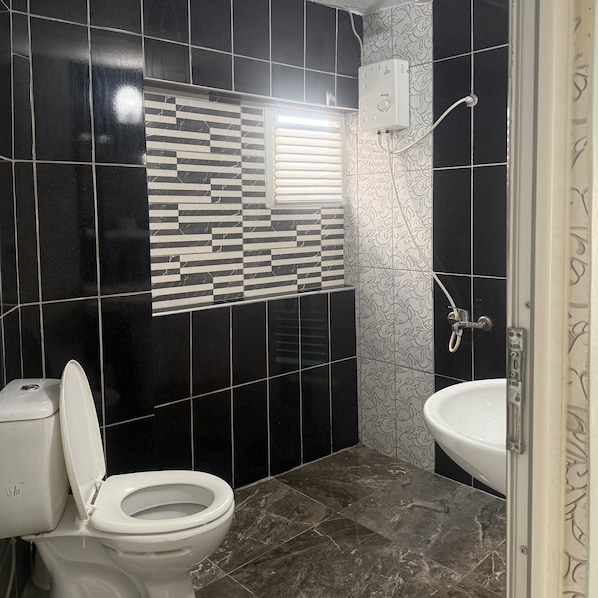 A bathroom with a toilet, a sink, and a shower. - Kisla Pansiyon (Antalya)
