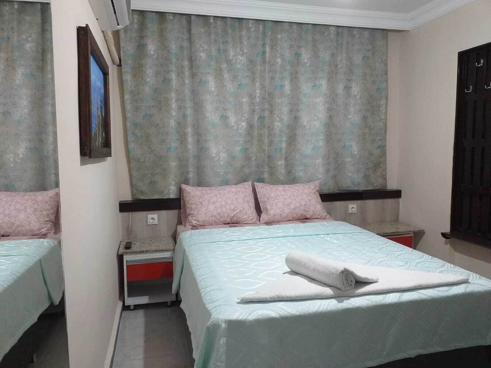 Une chambre d’hôtel avec deux lits, chacun doté d’une tête de lit et d’une table de chevet assorties.