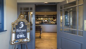 A bar area with a sign reading "Welcome to the OWL" and a wooden bench. - Owl, Hambleton by Marston's Inns (Selby)