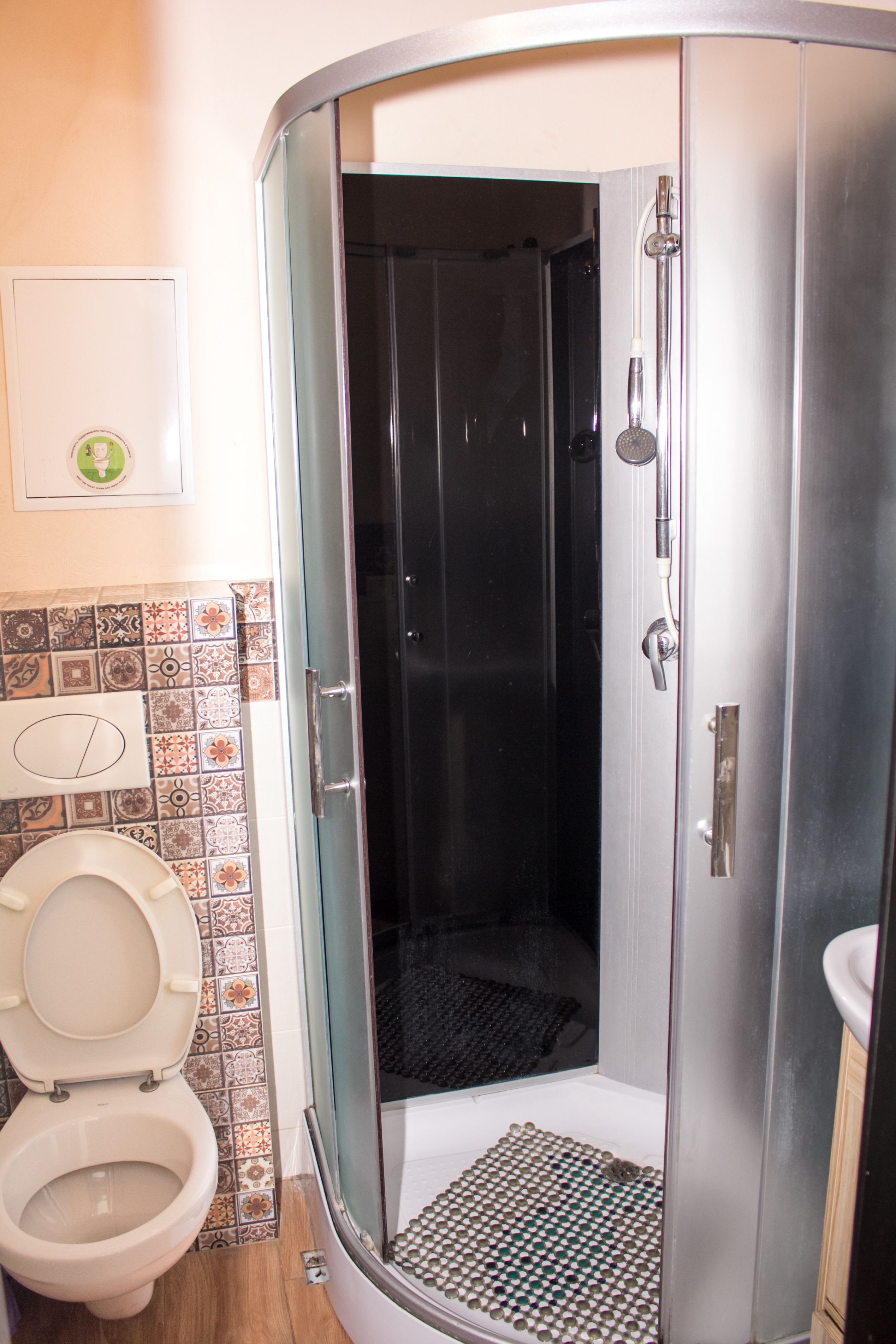 Un bagno con doccia, WC e pareti piastrellate.