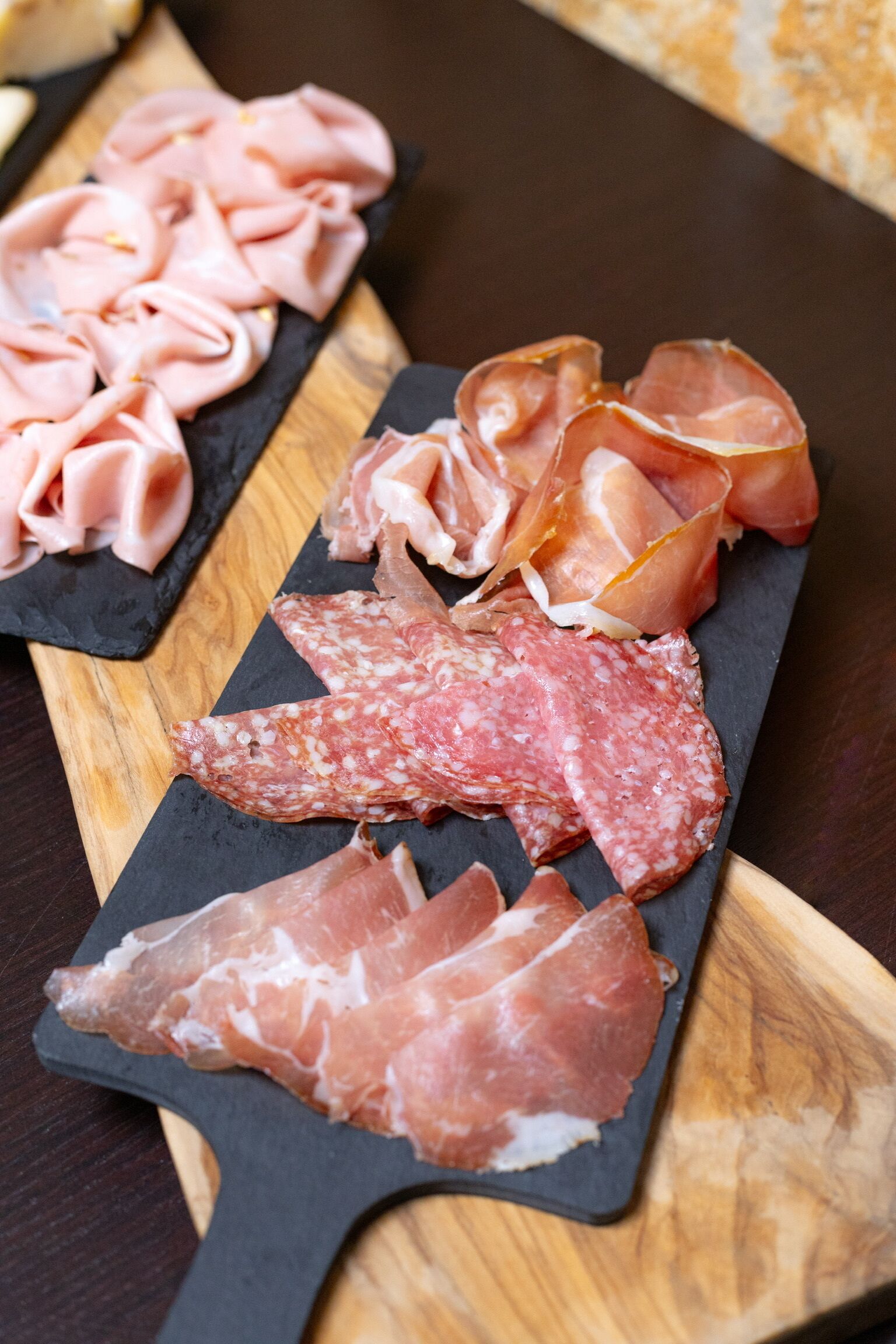 A variety of cured meats on a wooden board.