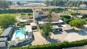 An aerial view of a residential area with a swimming pool, multiple houses, and a parking area. - Giardini di Marzo Lecce B&B (Lecce)