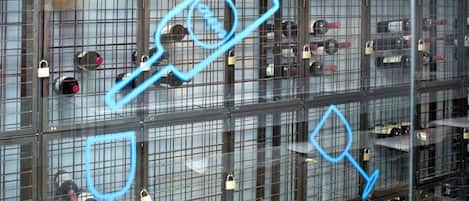 A large, modern building with multiple floors, each containing numerous rooms secured with metal bars and padlocks.