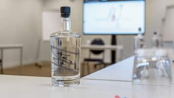 Une table de conférence avec une bouteille, un verre et un stylo.
