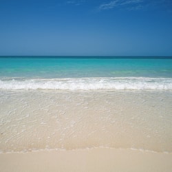 On the beach, white sand, sun-loungers, beach umbrellas