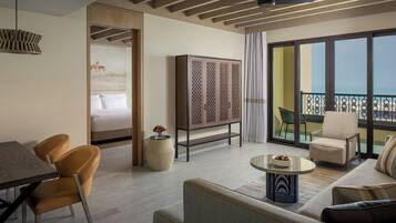A modern hotel room with a balcony, a dining area, and a sofa.