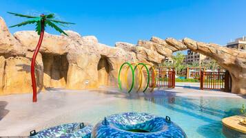 Enjoy a refreshing swim in the pool surrounded by a palm tree sculpture and large rocks.