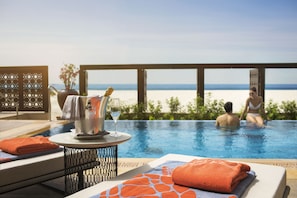 Relax by the pool with a refreshing view of the beach.