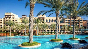 A resort with a swimming pool, palm trees, and a building with multiple balconies. - Saadiyat Rotana Resort and Villas (Abu Dhabi)