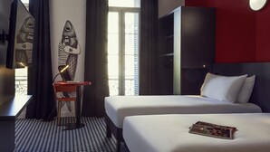 A hotel room with two beds, a desk with a chair, a large mirror, and a window with curtains. - Hôtel Ibis Styles Marseille Vieux Port (Marseille)