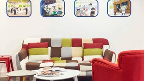 A cozy room with a colorful patchwork sofa, a red armchair, a small white table, and a magazine. - Hôtel Ibis Styles Marseille Vieux Port (Marseille)