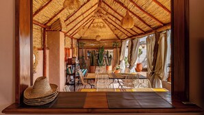 A room with a thatched roof, wicker furniture, and potted plants. - Riad Asrari  (Marrakech)