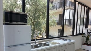 Una cocina moderna con microondas integrado, un lavamanos y armarios.