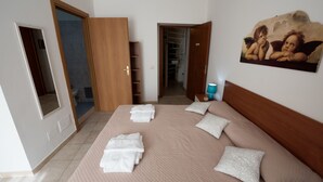 Ein Schlafzimmer mit einem großen Bett, einem Kleiderschrank, einem Schrank und einem Bild an der Wand.