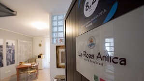Schild für das Bed & Breakfast La Rosa Anica mit Logos für Airbnb und Booking.com.