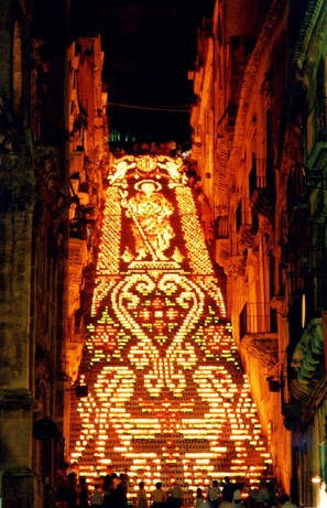 Une rue étroite où des motifs lumineux sont projetés sur les bâtiments, créant ainsi un spectacle saisissant.