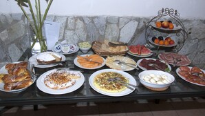 Una mesa de buffet con diversos alimentos, como frutas, pasteles y un bol de huevos.