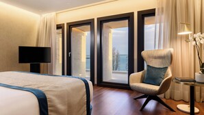 Une chambre d’hôtel avec un lit, une chaise, une télévision et une vue sur l’extérieur.