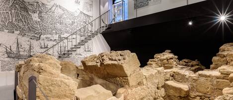 Eine archäologische Ausstellung mit antiken Ruinen, einer detaillierten Karte und Informationsschildern.