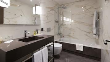 A modern bathroom with a dual sink vanity, a glass-enclosed shower, and a separate toilet.