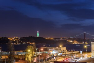 A nighttime cityscape with a prominent bridge and a lit tower.
