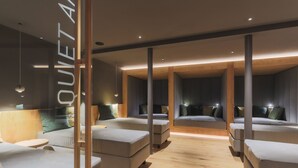 Et moderne hotelværelse med flere senge, trægulv og stemningsbelysning.
