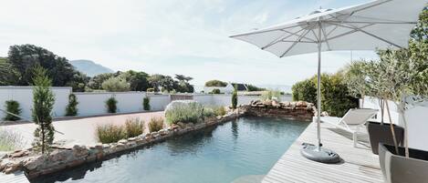 Piscine extérieure, parasols de plage, chaises longues