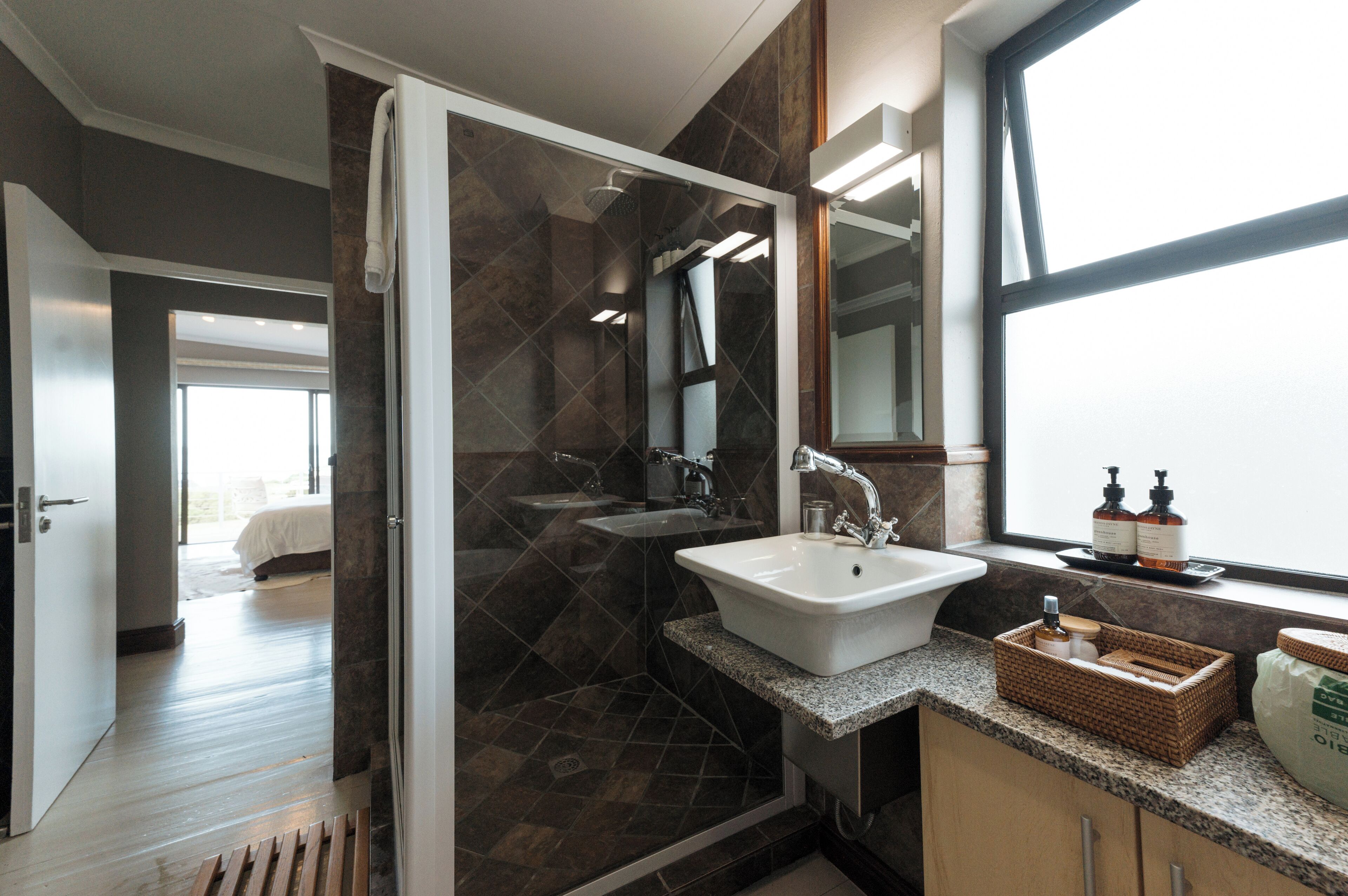 A modern bathroom with a glass shower enclosure, a sink, and a vanity.