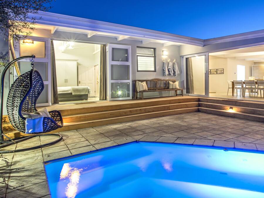Una piscina al aire libre, sombrillas, tumbonas
