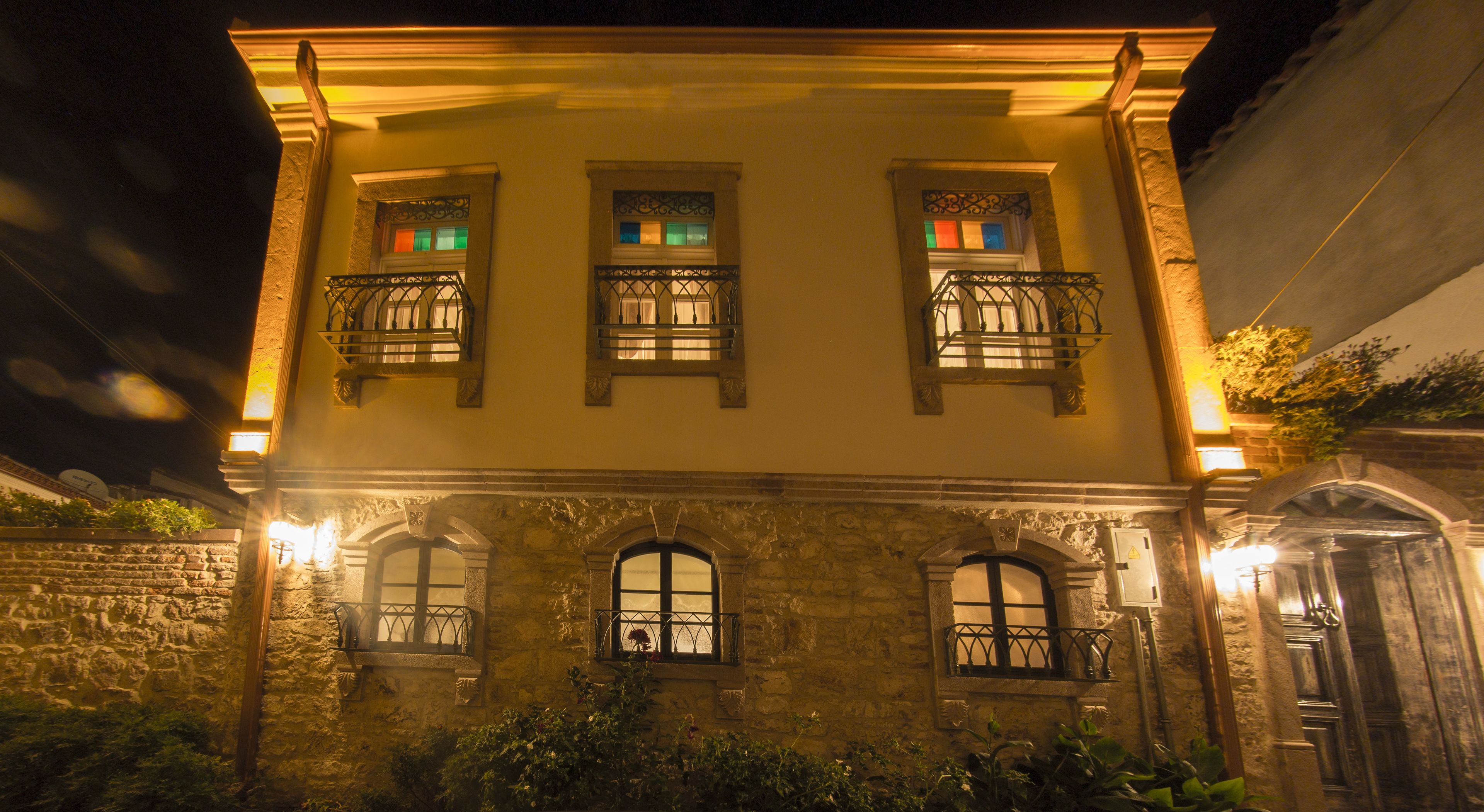 A historic building with three windows, each with a balcony and decorative ironwork.
