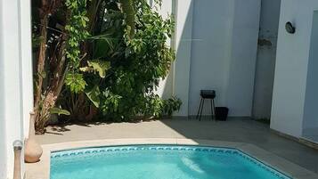 Una piscina al aire libre de temporada, sillones reclinables de piscina