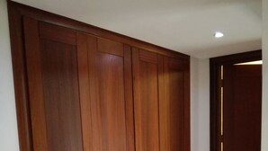 Ein großer, hölzerner Kleiderschrank mit mehreren Türen und einer kleinen, beleuchteten Leiste an der rechten Seite.