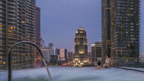 Un jacuzzi sur le toit, offrant une vue sur le paysage urbain et entouré de gratte-ciel.