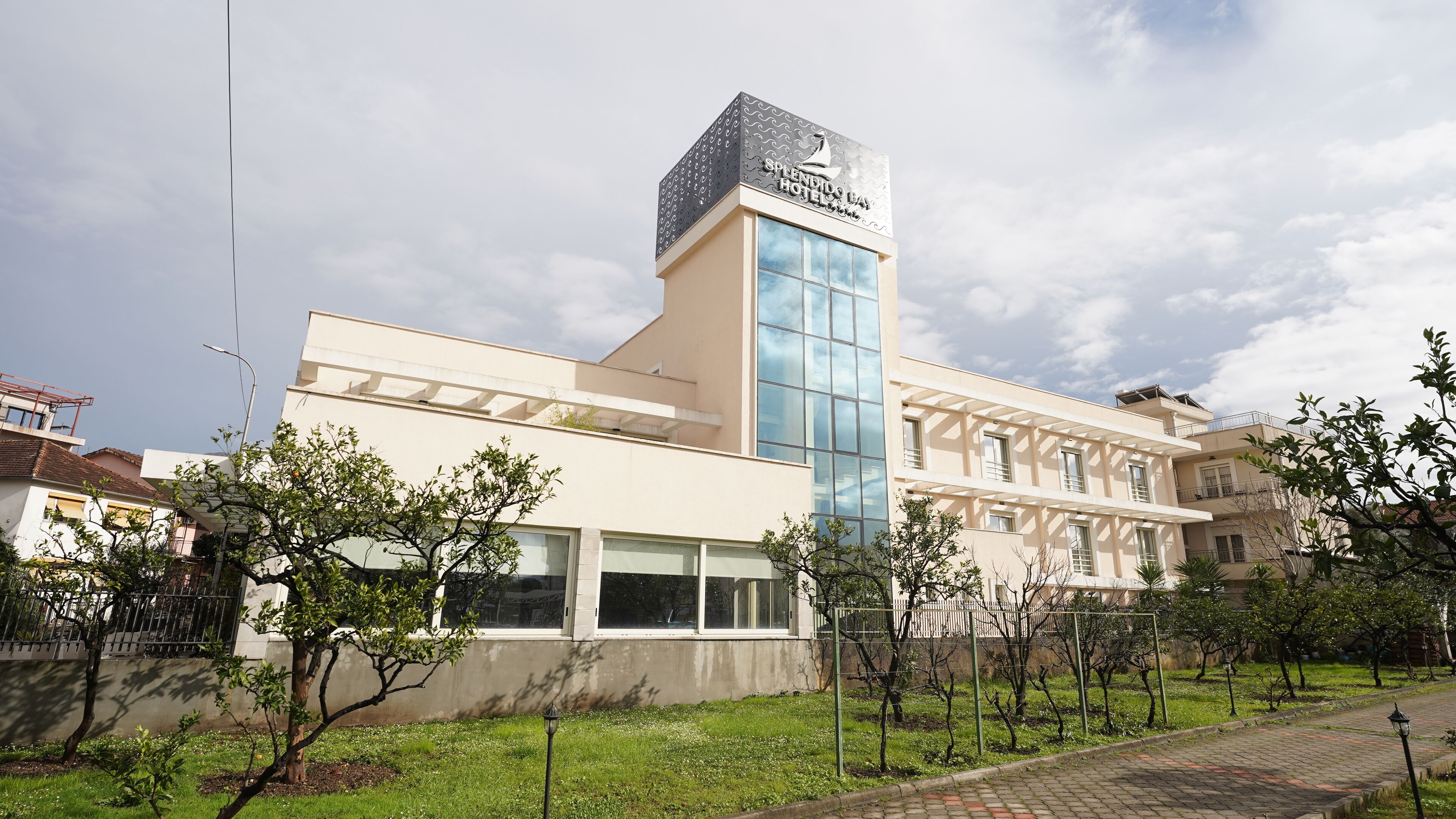 A modern hotel with a prominent tower and a large glass facade.