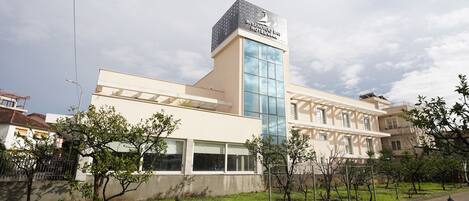 A modern hotel with a prominent tower and a large glass facade.