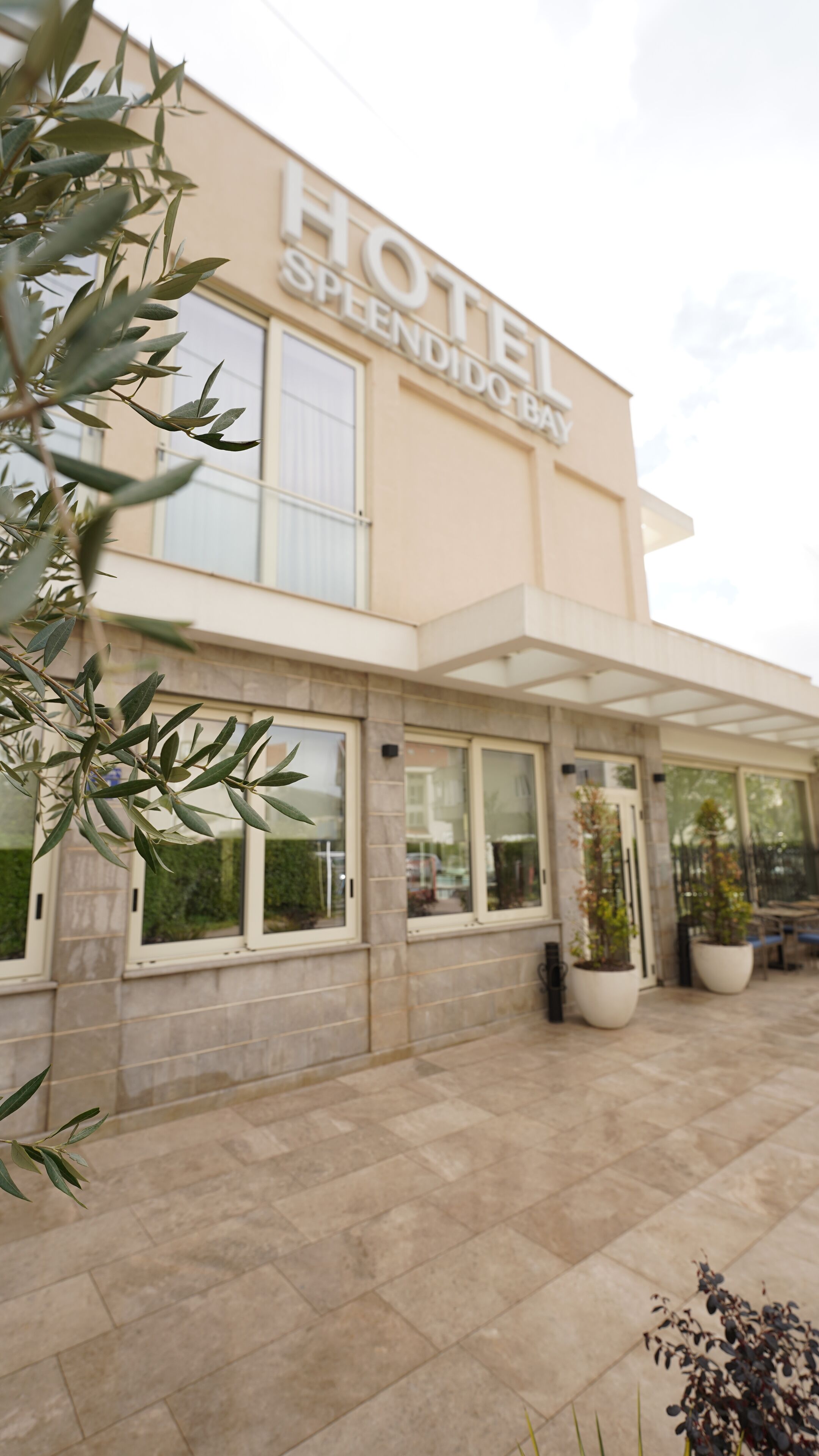 A hotel with a modern facade, large windows, and a sign that reads "HOTEL SPLENDIDO BAY".