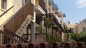 A modern building with a staircase, balconies, and terracotta roof tiles. - Hotel Kings Annex (Paphos)