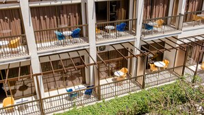 A multi-story hotel with balconies, outdoor seating areas, and a view of the surrounding greenery. - Hotel Kings Annex (Paphos)