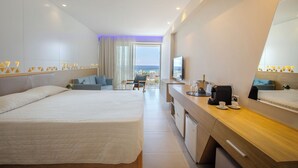 A modern hotel room with a large bed, a desk with a coffee machine, and a view of the sea. - Tasia Maris Seasons (Ayia Napa)