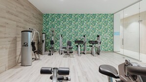 A gym with various exercise equipment, including a Cybex machine, dumbbells, and a stationary bike. - Tasia Maris Seasons (Ayia Napa)