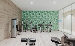 A gym with various exercise equipment, including a Cybex machine, dumbbells, and a stationary bike. - Tasia Maris Seasons (Ayia Napa)