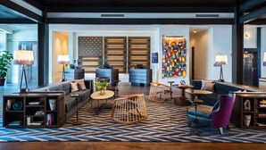 A modern lobby with a reception desk, seating area, and a colorful wall display. - Renaissance Columbus Westerville-Polaris Hotel (Westerville)