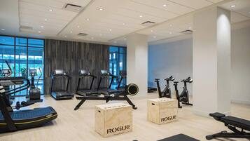 Un gimnasio moderno con cintas de correr, elípticas y bicicletas estáticas.