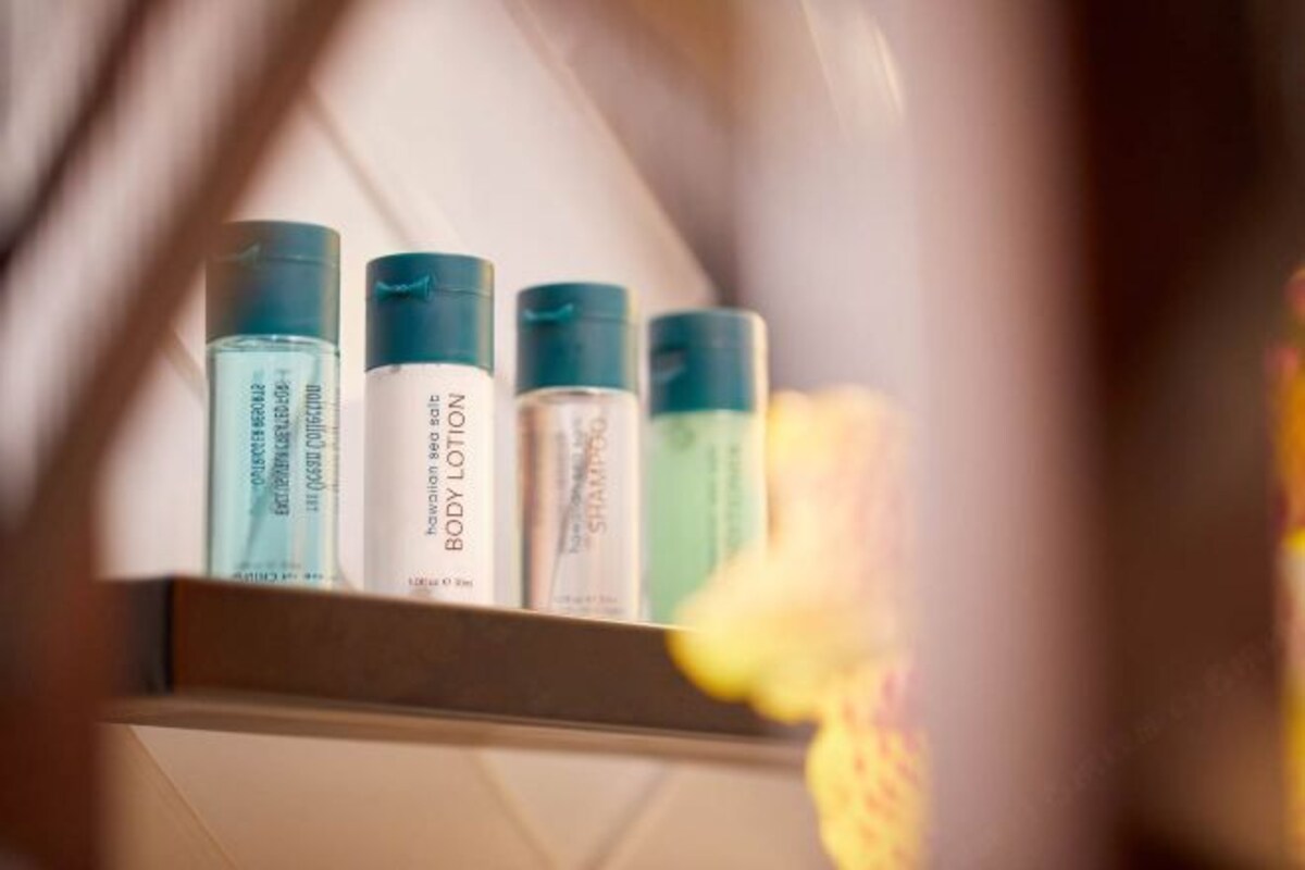 A shelf with various toiletries, including body lotion and shampoo.