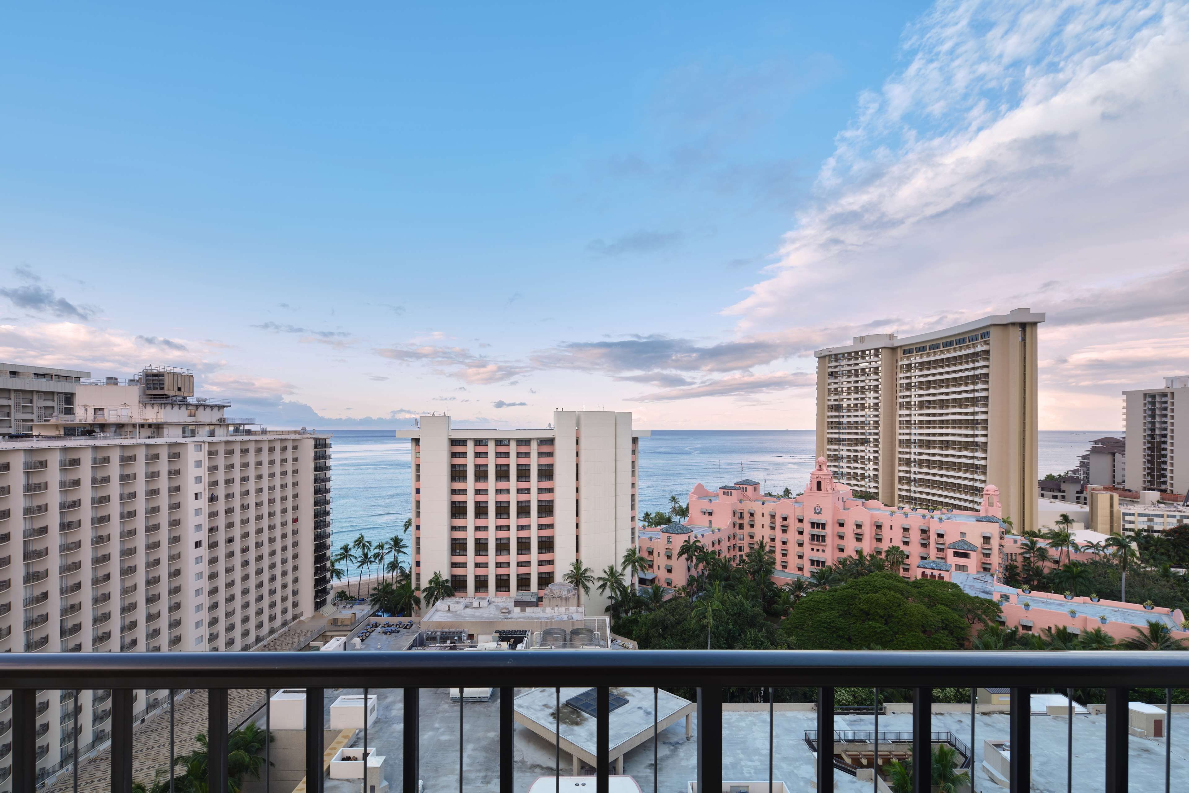 Un hotel de altura con varias plantas, vistas a la playa y zona de piscina.