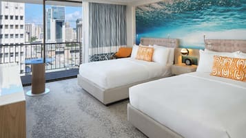 A hotel room with two beds, a city view, a balcony, and a large ocean-themed mural.